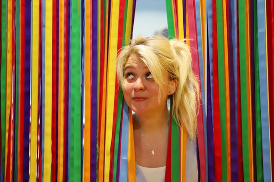 A young happy blond woman against colourful background