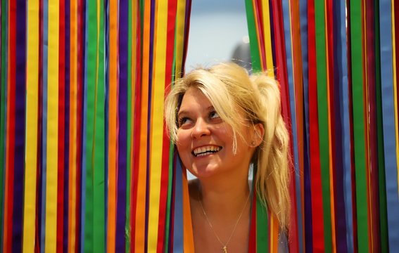 A young happy blond woman against colourful background
