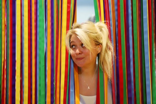 A young happy blond woman against colourful background
