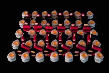 candy fried eggs with black and red gummy on a mirror with a black background