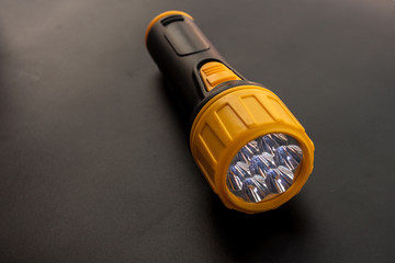 Yellow and black LED Flashlight on the black background, Emergency tool for darkness 