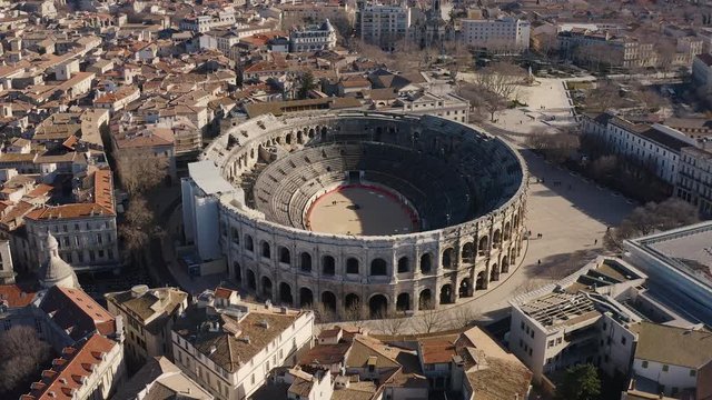 Aerial view flying around the Arena of N&icirc;mes a roman amphitheatre during winter sunny day 