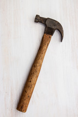 vintage old hammer steel handle tool on wood white paint background