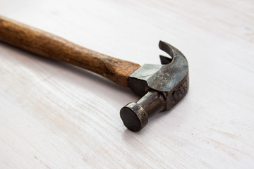 vintage old hammer steel handle tool on wood white paint background