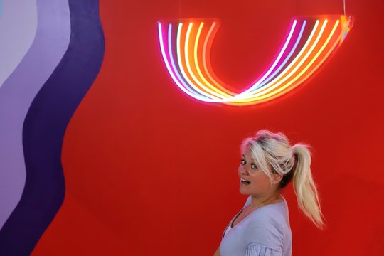 A young blond woman against a red colourful background