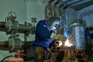 Welder worker at industrial arc welding work