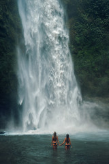 girls enter the waterfall