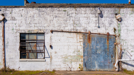 Old building textured surface with rusty steel door and window