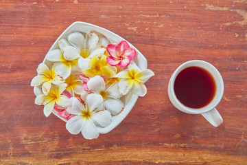 Mornin coffee / tea on a table with frangipani flowers.
