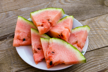 Sliced watermelon in a plate on wooden table