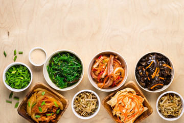 Selection of Korean Asian food in bowls on wooden background