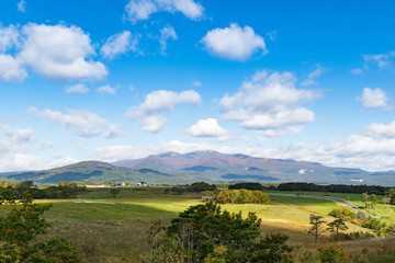 Fototapeta na wymiar 宮城栗駒高原紅葉の栗駒山と牧場とフェンスに囲まれた放牧場