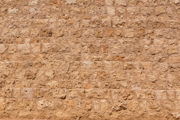 light brown wall made of coquina stones
