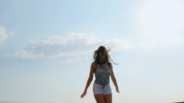 Happy young beautiful woman jumping, blue sky background. 180 fps