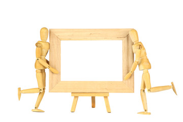 Wooden dolls hold a frame on a white background