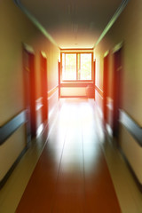 Long corridor doors of the building walkway with blur and light at the end