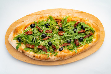 vegan pizza with dried tomatoes, olives and arugula salad