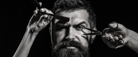 Barber scissors and straight razor, barbershop. Mens haircut, shaving. Bearded man, long beard, brutal, caucasian hipster with moustache. Vintage barbershop.