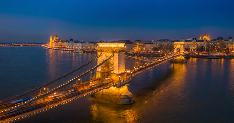 Fototapeta na wymiar Budapest, Hungary - Aerial panormaic view of the famous illuminated Szechenyi Chain Bridge at blue hour with Parliament building and St.Stephen's Basilica at the background