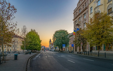 Fototapeta na wymiar Cluj-Napoca city center. View from the Unirii Square to the Eroilor Avenue, Heroes' Avenue - a central avenue in Cluj-Napoca, Romania