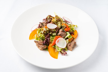salad with beef and persimmon on the white plate