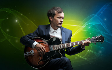 Fototapeta na wymiar Serious classical guitarist with fabled sparkling wallpaper