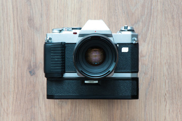 Old film camera isolated on wooden background