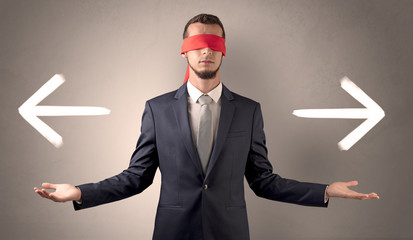 Covered eye businessman choosing between two directions 