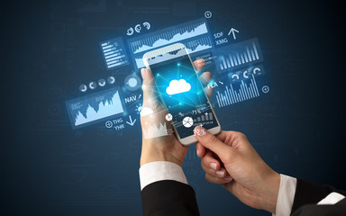 Female hand using smartphone with financial tracking concept illustrated by graphs and symbols