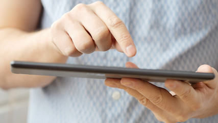 Man hand touching screen on modern digital tablet pc.