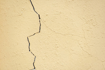 Crack in the yellow plastered wall