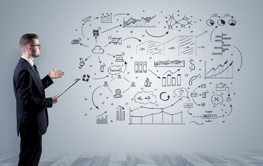 Manager staying and presenting office affairs for someone with graphs, icons reports around
