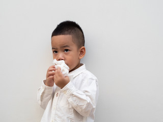 sick asian boy blow his nose into tissue