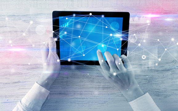 Hand using tablet with linking graphs charts  report and informational flow concept
