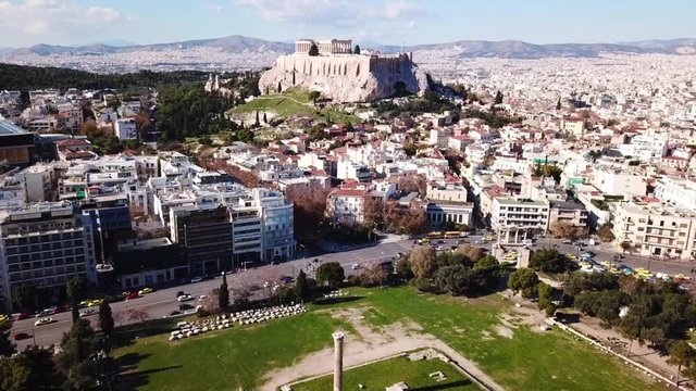 Aerial birds eye view video taken by drone of iconic pillars of temple of Zeus and Acropolis hill at the background, Athens historic center, Attica, Greece