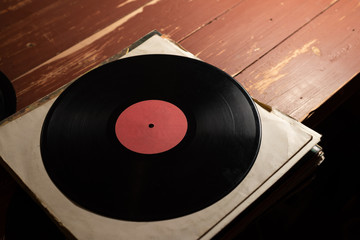 vinyl record on old red wooden background. Copy space for your label