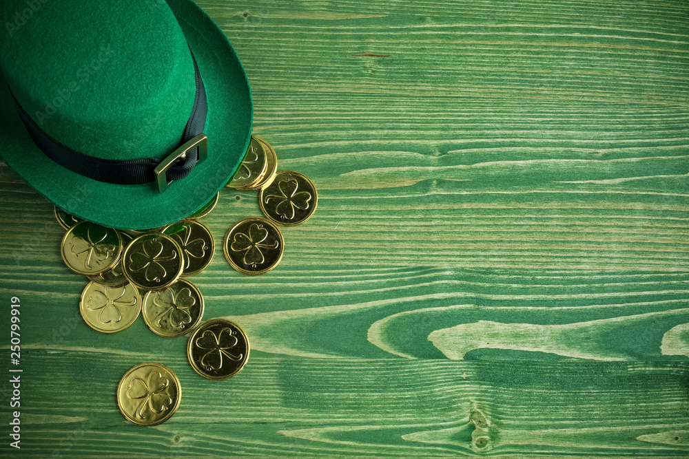 Wall mural happy st patricks day leprechaun hat with gold coins on vintage green wood background