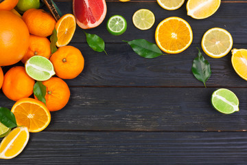 Bright composition of citrus fruits on black wooden background