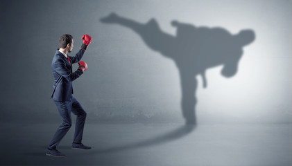 Fototapeta premium Businessman fighting with his strong karate man shadow 