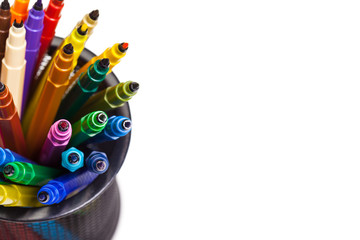 Obraz premium Set of markers in a cup and a piece of paper on white background