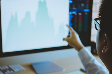 Hand of businessman  pointing and look directions change Average line Share price movement Stock trading in the up and down. On the display screen Computer.