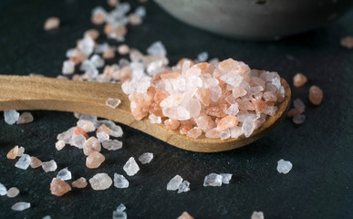 Fototapeta na wymiar Wooden spoon with pink himalayan salt macro