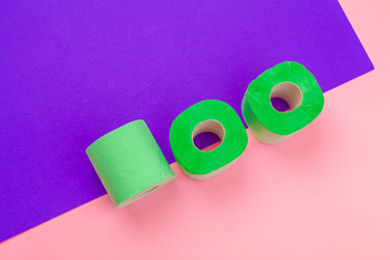 Green toilet paper roll on bright color block background top view