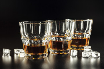 Whiskey and ice on rustic wood background