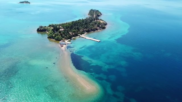 Aerial drone bird's eye view video of tropical caribbean island forming atoll with beautiful turquoise and sapphire clear waters