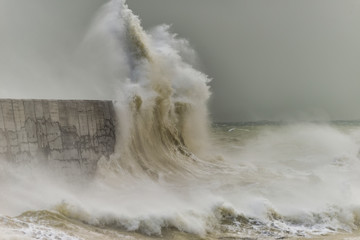 Stunning dangerous high waves crashing over harbor wall during windy Winter storm at Newhaven on...