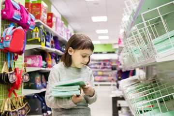 schoolgirl buying notebooks