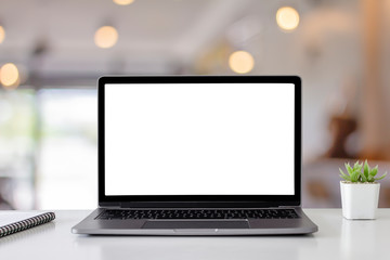 Mockup digital laptop blank white screen on wood table at  coffee shop