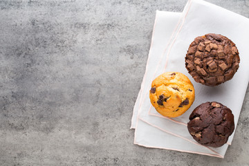 Homemade chocolate muffins on the vintage background.
