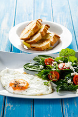 Breakfast - fried egg, toasts and vegetable salad